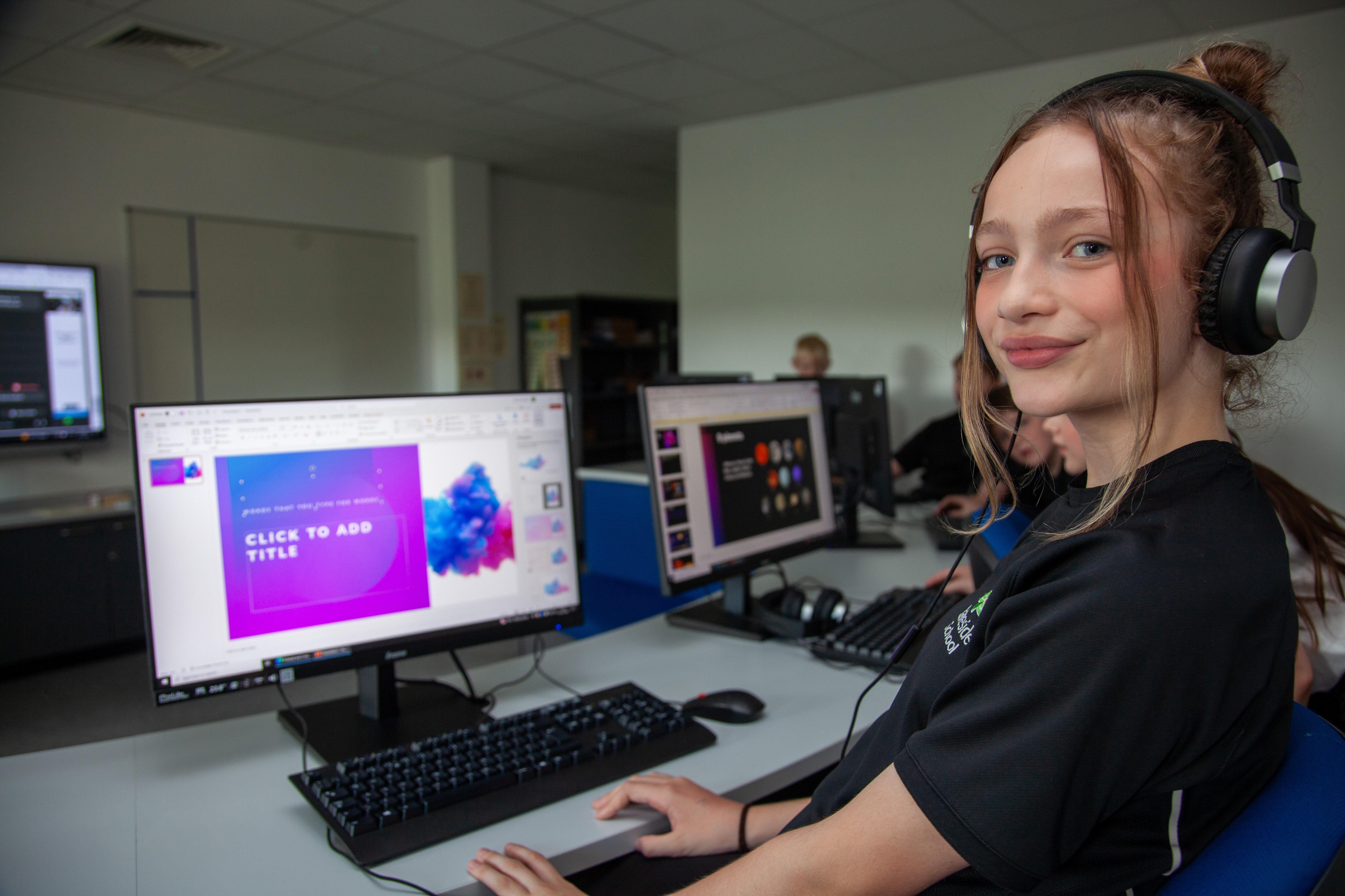 A young girl at Lakeside School using a computer and headphones