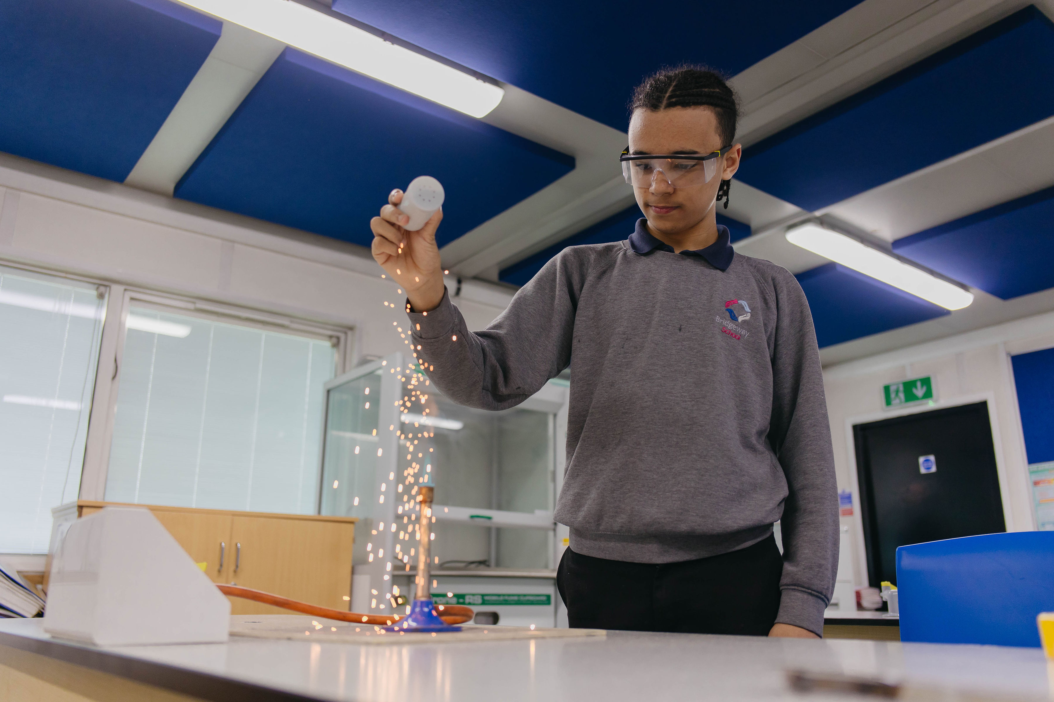 A young boy at Bridgeway School working in a science lesson wearing safety glasses