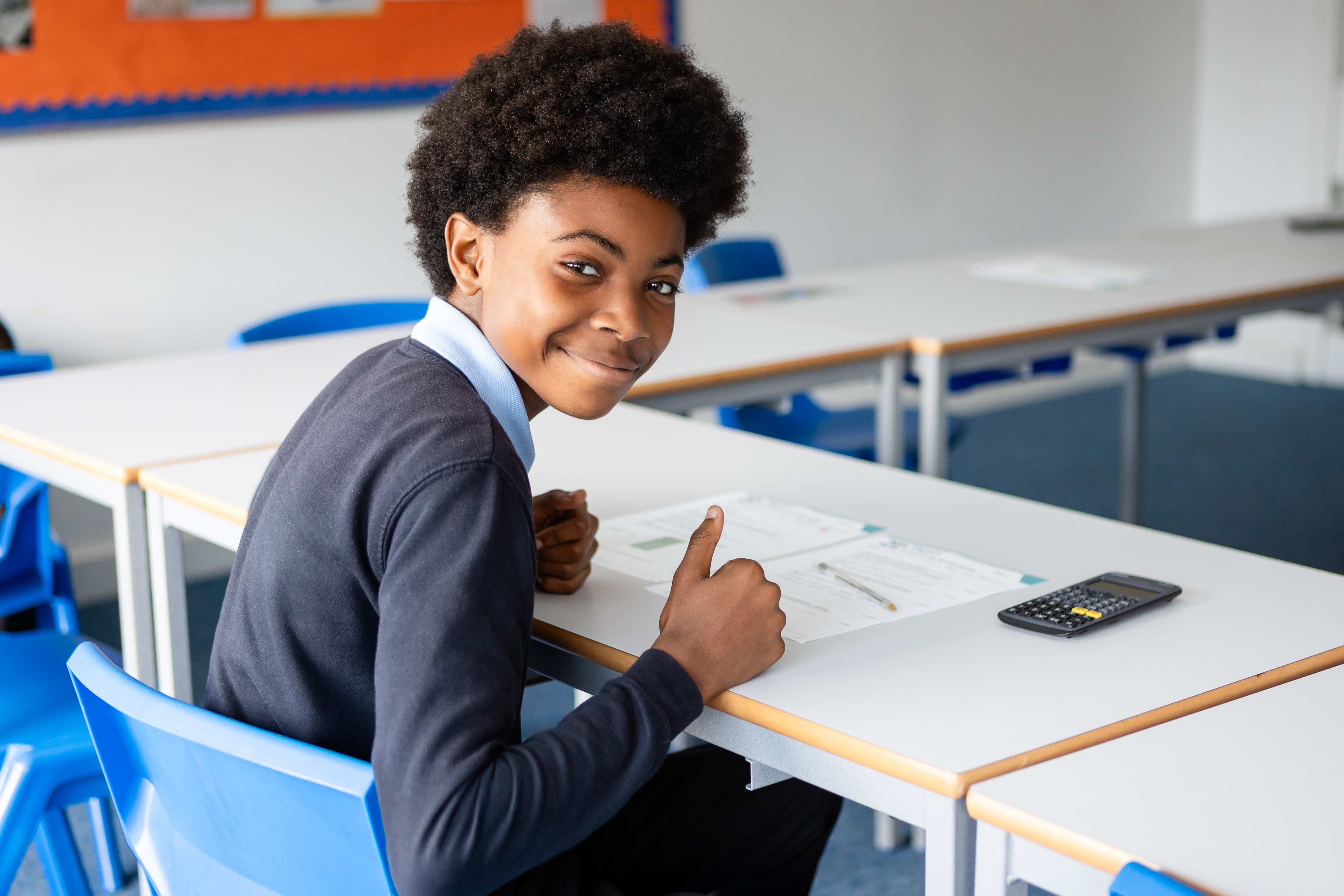 Young boy from Queensmead House School sat at a desk doing school work 